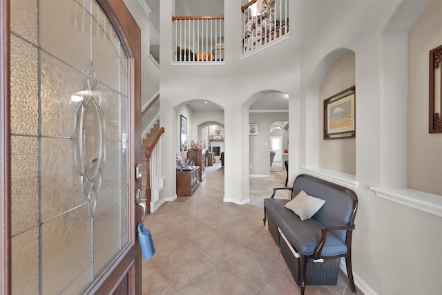 tiled foyer entrance featuring a towering ceiling