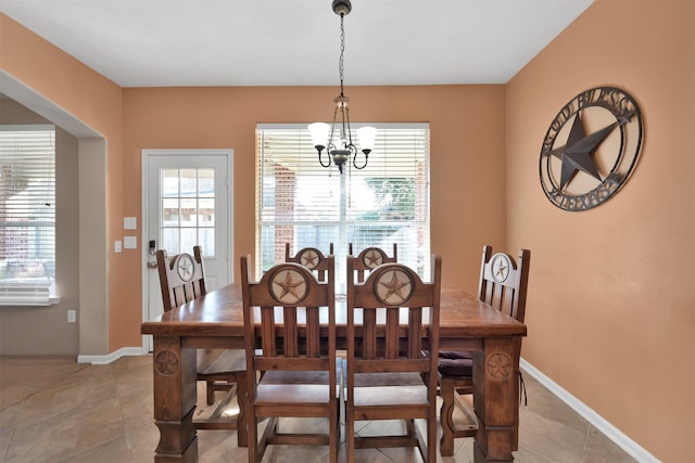 tiled dining area featuring an inviting chandelier