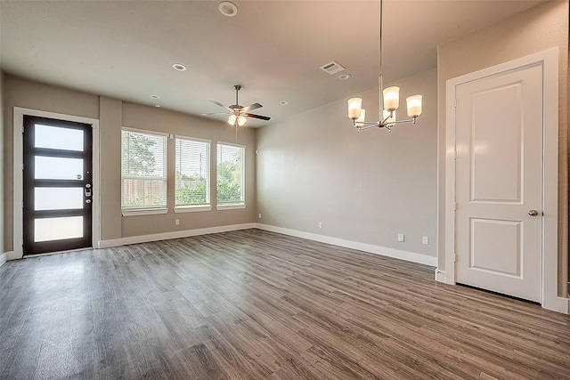 unfurnished room featuring dark hardwood / wood-style flooring and ceiling fan with notable chandelier