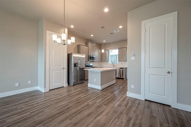 kitchen featuring backsplash, stainless steel appliances, a kitchen island, dark hardwood / wood-style flooring, and decorative light fixtures