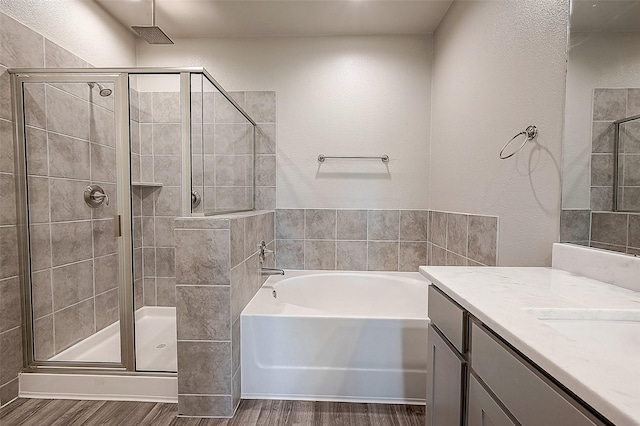 bathroom with hardwood / wood-style flooring, vanity, and separate shower and tub