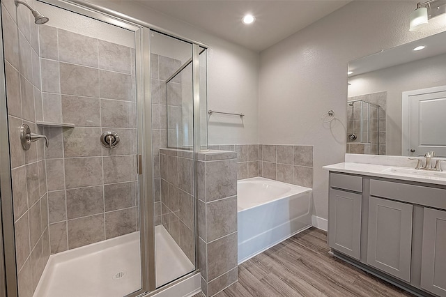 bathroom with vanity, hardwood / wood-style floors, and independent shower and bath