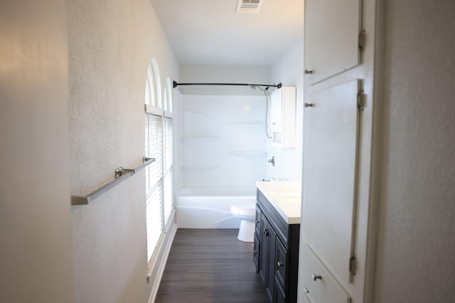 full bathroom featuring vanity, hardwood / wood-style floors,  shower combination, and toilet