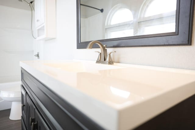 bathroom featuring vanity, a shower, and toilet