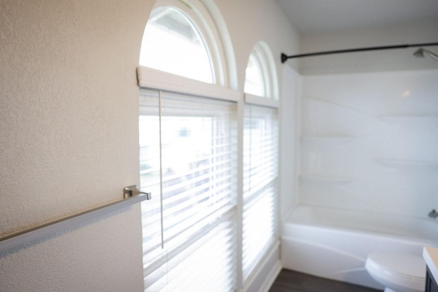 full bathroom with shower / bathing tub combination, vanity, plenty of natural light, and toilet