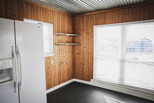 kitchen with concrete floors and white fridge with ice dispenser