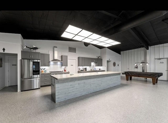 kitchen featuring wall chimney exhaust hood, billiards, appliances with stainless steel finishes, and gray cabinets