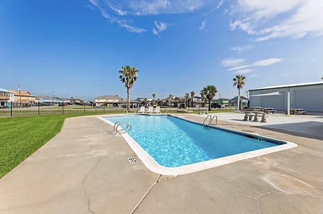 view of pool featuring a lawn and a patio