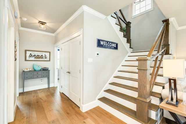 entryway featuring ornamental molding and light hardwood / wood-style flooring