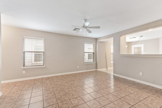 empty room with light tile patterned floors, a textured ceiling, and ceiling fan