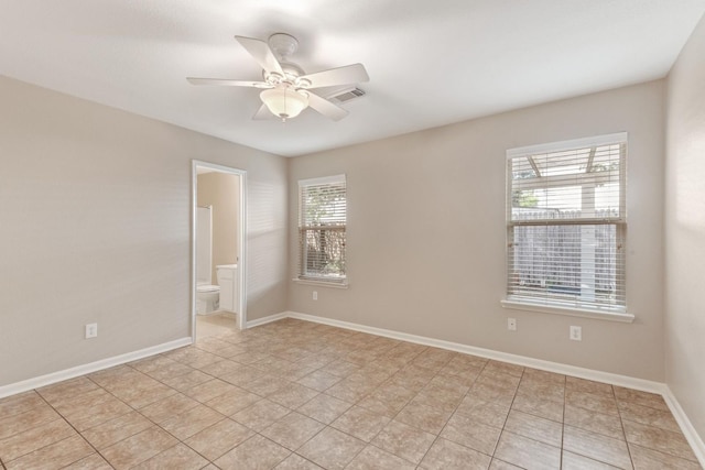 tiled spare room featuring ceiling fan