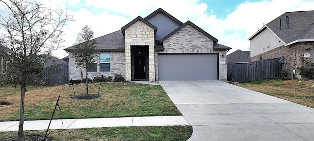 view of front of home featuring fence, driveway, a front lawn, stone siding, and a garage