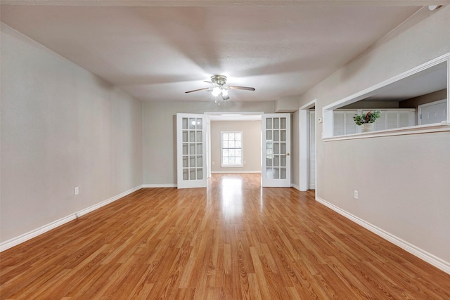 unfurnished room with french doors, ceiling fan, and light hardwood / wood-style flooring