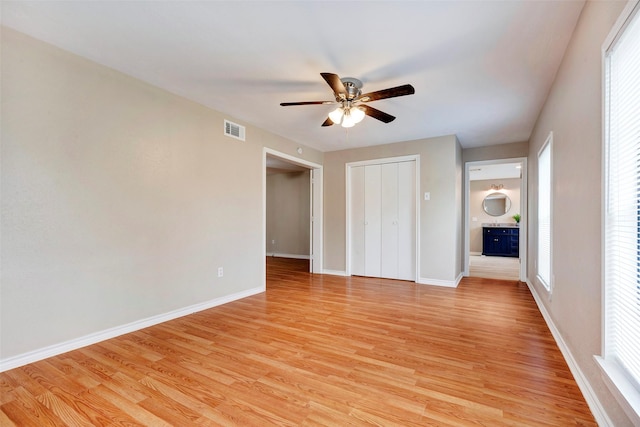 unfurnished bedroom featuring ceiling fan, light hardwood / wood-style floors, and a closet