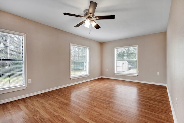 empty room with ceiling fan and light hardwood / wood-style flooring