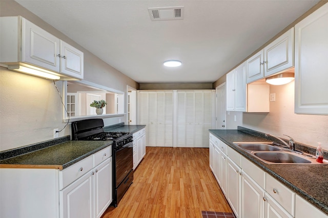 kitchen featuring white cabinetry, black range with gas stovetop, sink, and light wood-type flooring