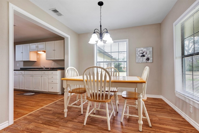 dining space with a chandelier and light hardwood / wood-style flooring