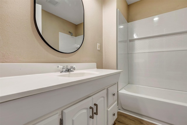 bathroom featuring vanity, hardwood / wood-style flooring, and  shower combination