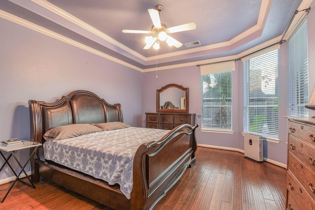 bedroom with dark hardwood / wood-style floors, ornamental molding, a raised ceiling, and ceiling fan