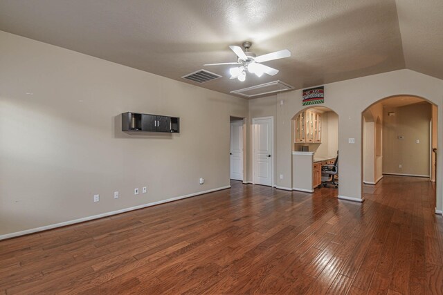 unfurnished living room featuring dark wood-type flooring, ceiling fan, and vaulted ceiling