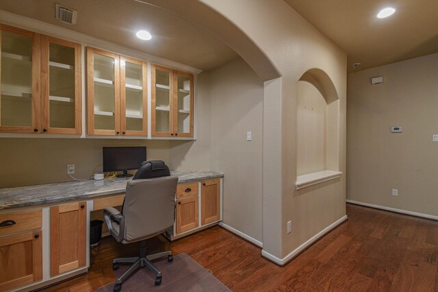 home office with built in desk and dark wood-type flooring