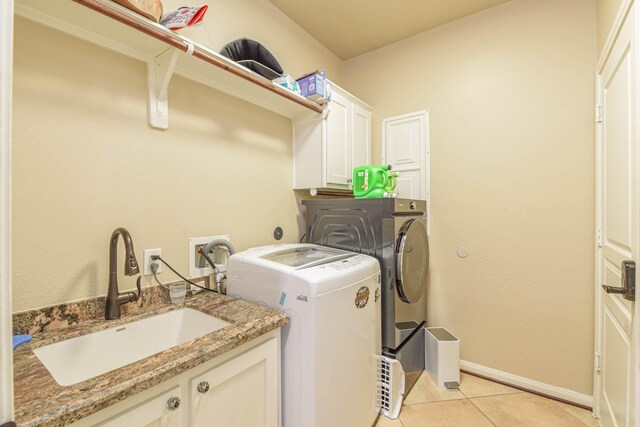 laundry room featuring cabinets, washing machine and dryer, sink, and light tile patterned flooring