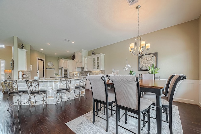 dining area featuring a notable chandelier and dark wood-type flooring