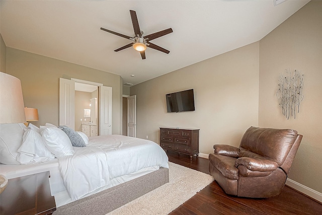 bedroom with ensuite bathroom, dark wood-type flooring, and ceiling fan