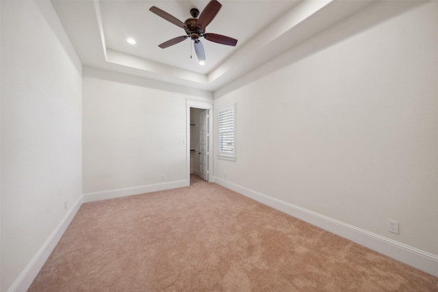 unfurnished room with recessed lighting, a tray ceiling, baseboards, light colored carpet, and ceiling fan