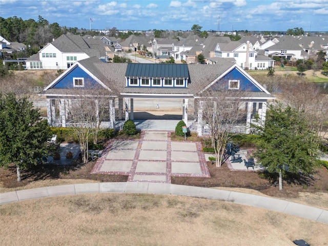 view of front of home with a residential view, a porch, and concrete driveway