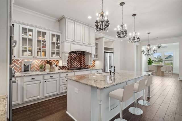 kitchen with ornamental molding, gas stovetop, an inviting chandelier, white cabinetry, and dark wood-type flooring