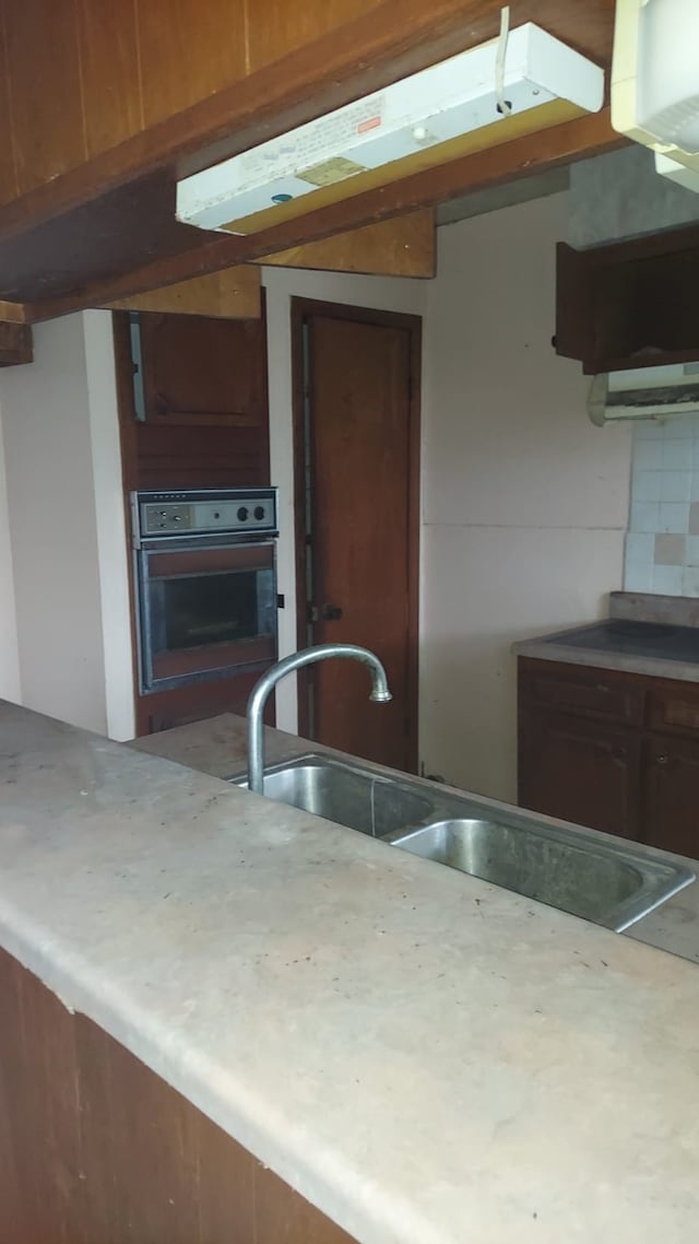 kitchen with sink, wall oven, and decorative backsplash