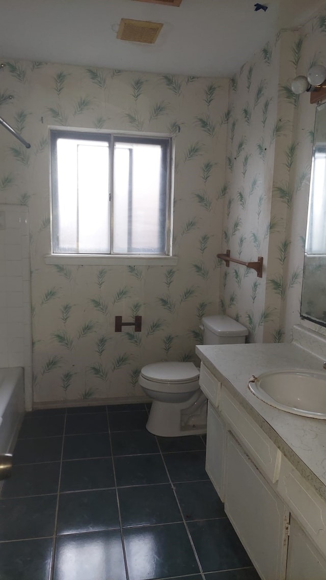 bathroom with tile patterned floors, toilet, vanity, and a wealth of natural light