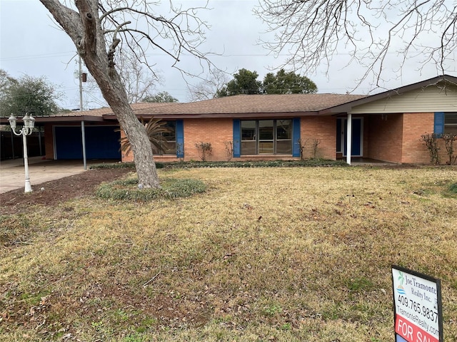 ranch-style home featuring a carport and a front yard