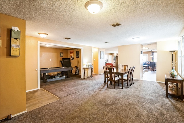 dining area with carpet flooring and a textured ceiling