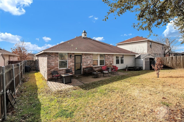 back of property featuring a storage unit, a fire pit, a patio area, and a lawn