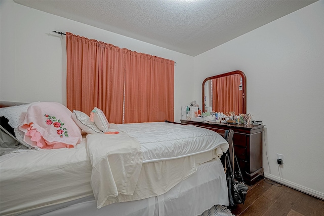 bedroom with dark hardwood / wood-style flooring and a textured ceiling