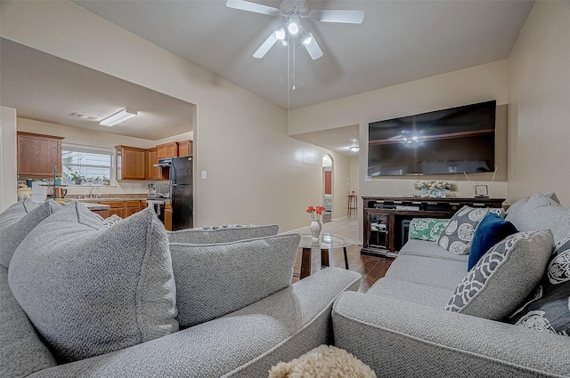 living room with wood-type flooring and ceiling fan