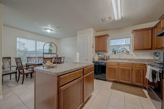 kitchen featuring electric stove, sink, a kitchen island, black dishwasher, and light tile patterned flooring