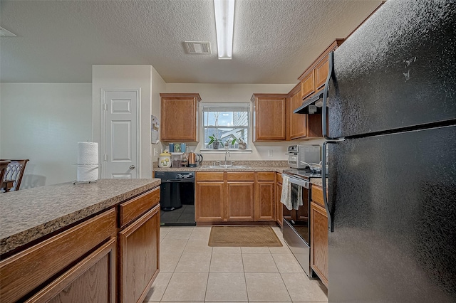 kitchen featuring light tile patterned flooring, sink, black appliances, a textured ceiling, and exhaust hood