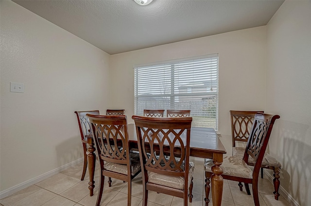 tiled dining space featuring a textured ceiling