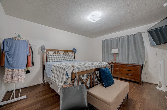 bedroom featuring dark hardwood / wood-style floors and a textured ceiling