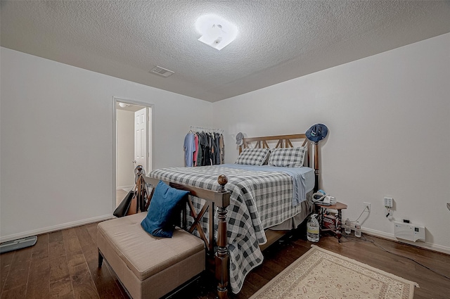 bedroom featuring dark hardwood / wood-style floors and a textured ceiling