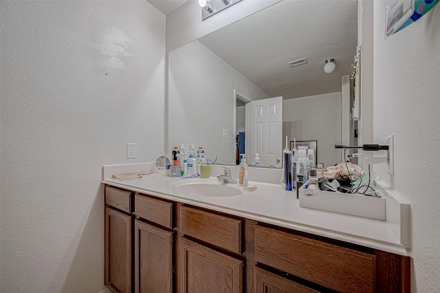 bathroom with vanity and a textured ceiling