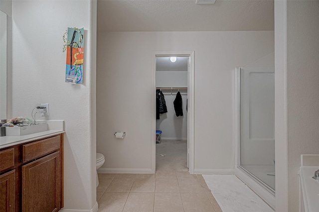 bathroom featuring walk in shower, tile patterned floors, toilet, and vanity