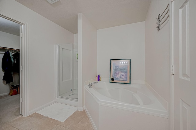 bathroom featuring tile patterned floors, shower with separate bathtub, and a textured ceiling