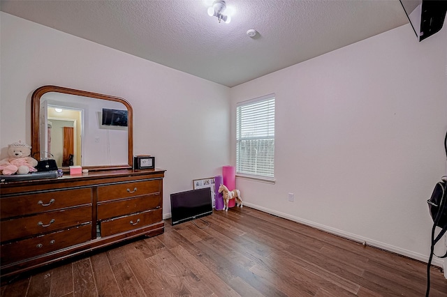 bedroom featuring wood-type flooring and a textured ceiling