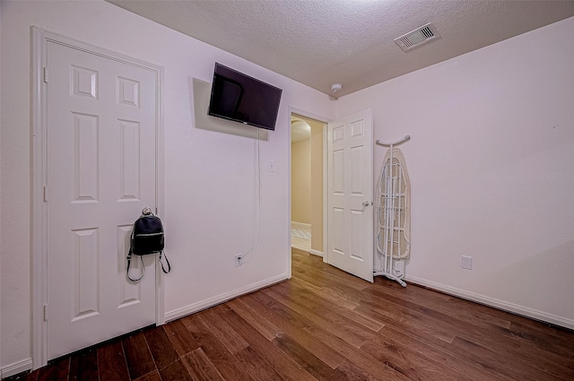 unfurnished bedroom featuring hardwood / wood-style floors and a textured ceiling