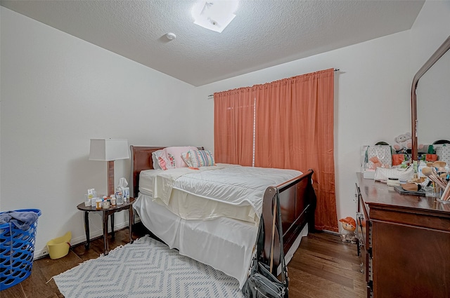 bedroom with dark wood-type flooring and a textured ceiling