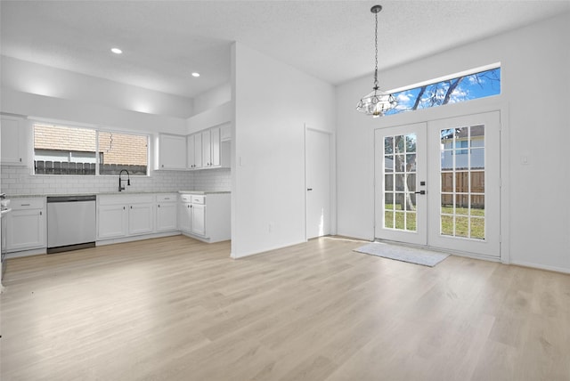 kitchen with dishwasher, decorative backsplash, white cabinets, decorative light fixtures, and light wood-type flooring